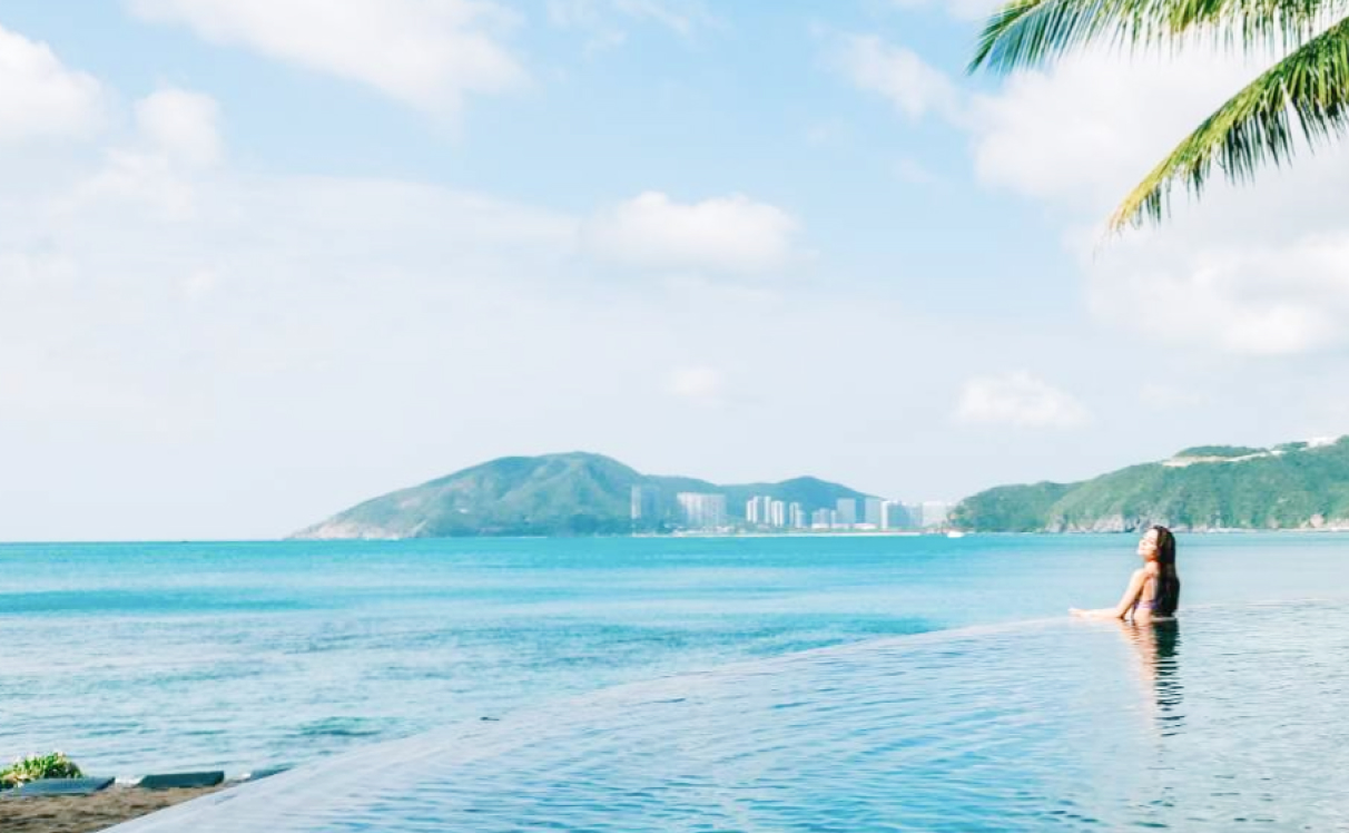 Woman swimming in the ocean with city in background